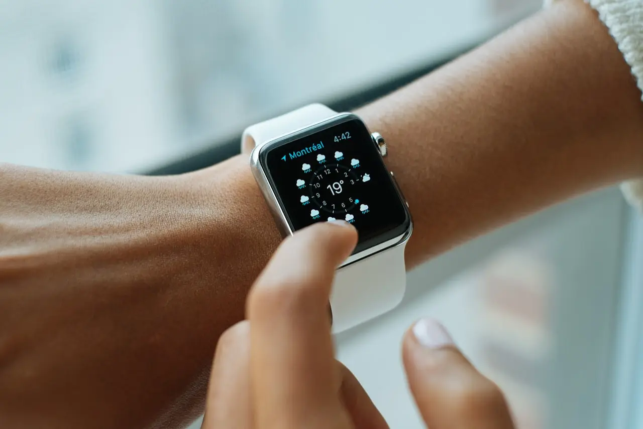 Smartwatch on a wrist next to a smartphone