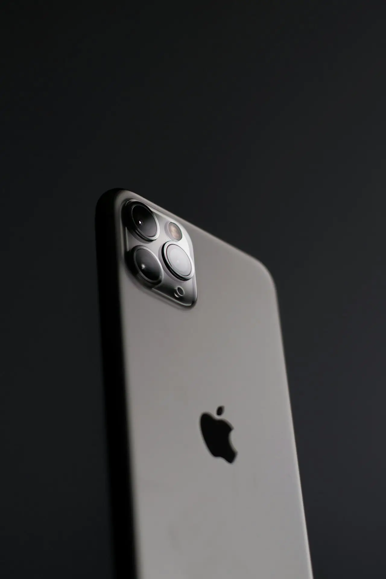Person holding an iPhone showing the home screen